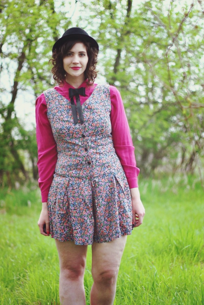 Pink button up under a floral romper and topped off with a black bow tie.