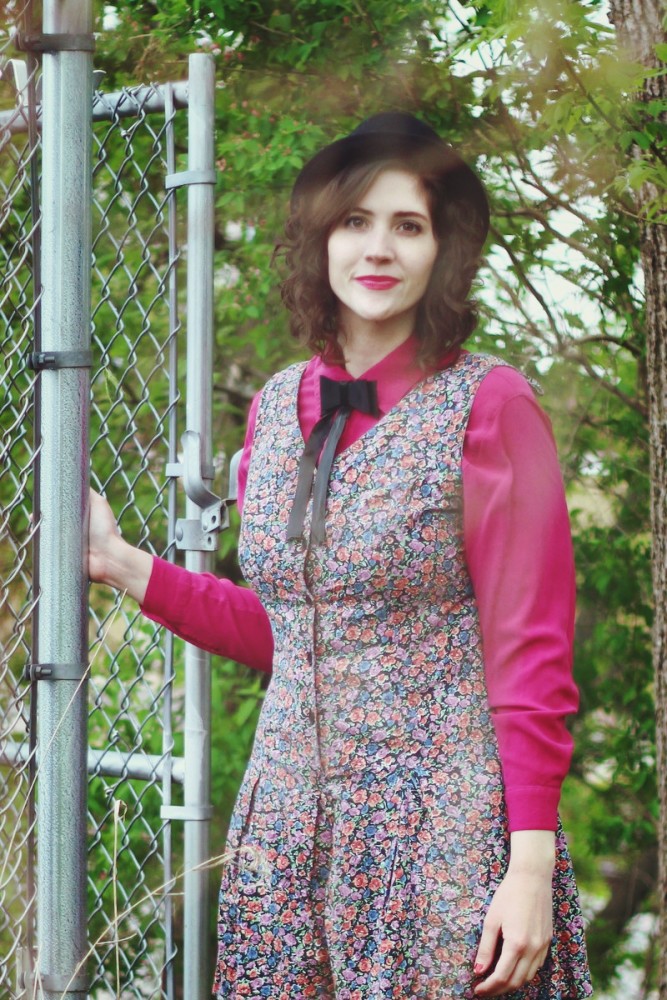 Pink button up under a floral romper and topped off with a black bow tie.
