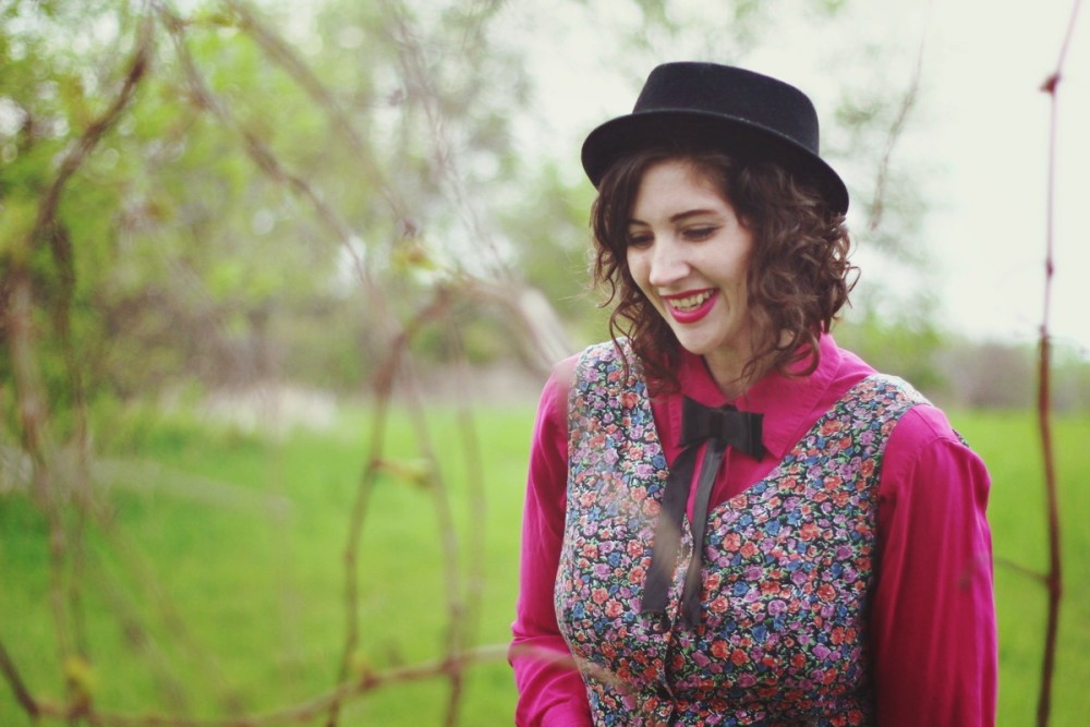 Pink button up under a floral romper and topped off with a black bow tie.
