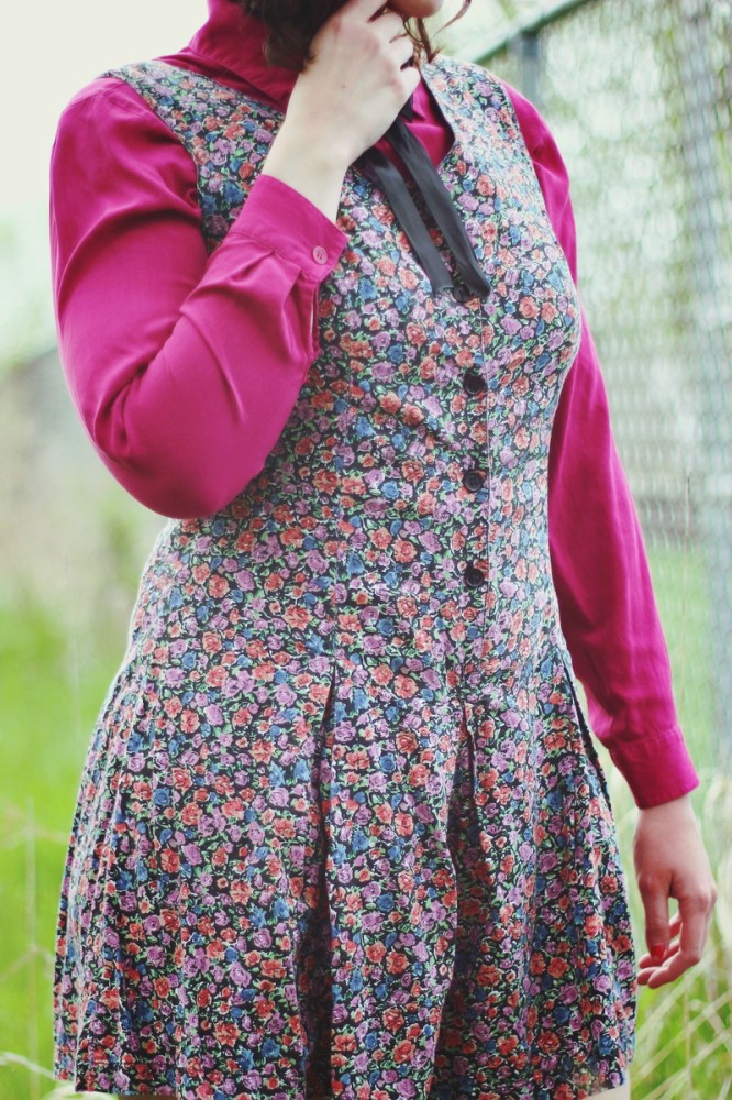 Pink button up under a floral romper and topped off with a black bow tie.