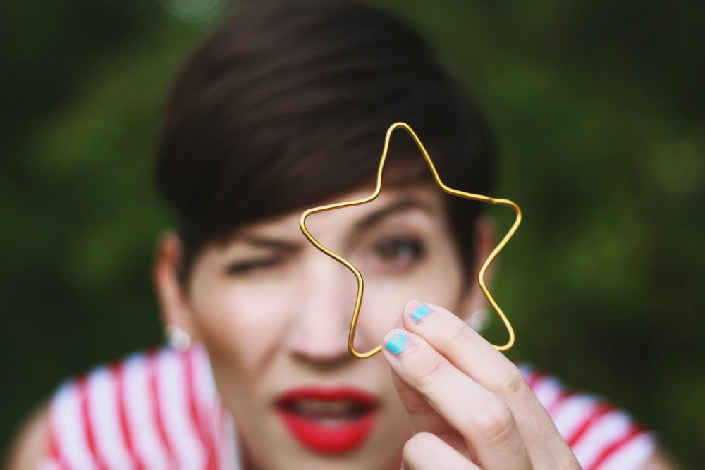 Patriotic outfit with a red striped top, blue polka dotted skirt, and DIY star bracelet.