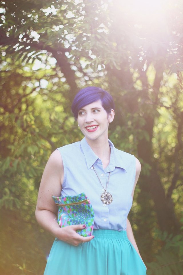 Purple pixie cut, gold medallion necklace, vintage patterned clutch