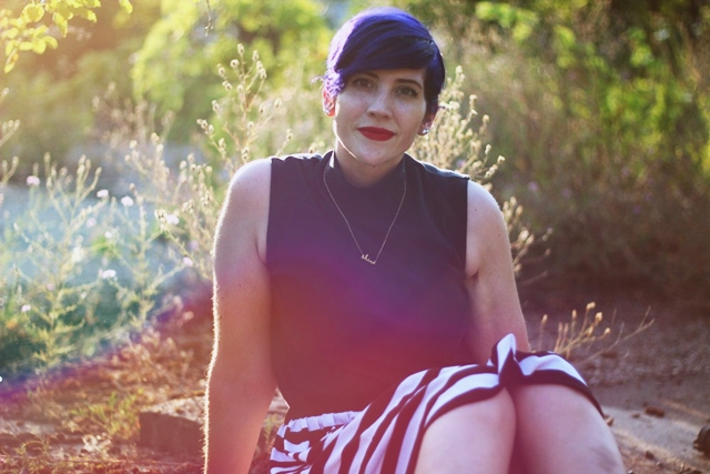 Outfit: Outfit: Striped skirt, black sleeveless mock turtleneck, dainty gold necklace, purple pixie cut