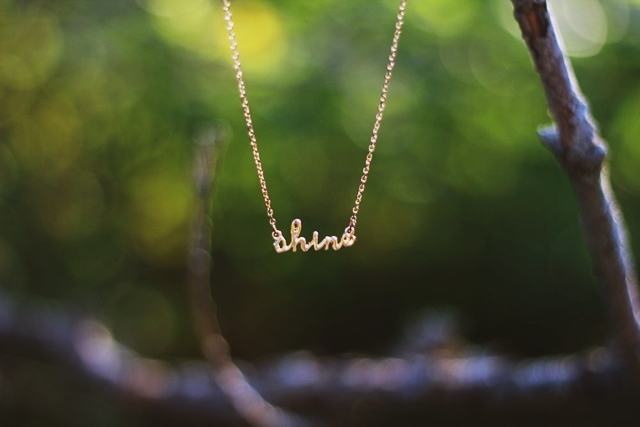 Dainty gold necklace that says "shine"