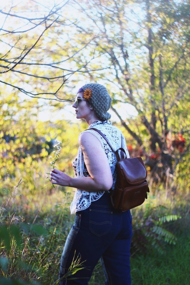 1970s Inspired Outfit: Floral blouse, white lace vest, high waisted dark wash denim, mini brown backpack