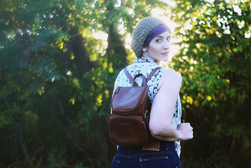 1970s Inspired Outfit: Floral blouse, white lace vest, high waisted dark wash denim, high heels, mini brown backpack