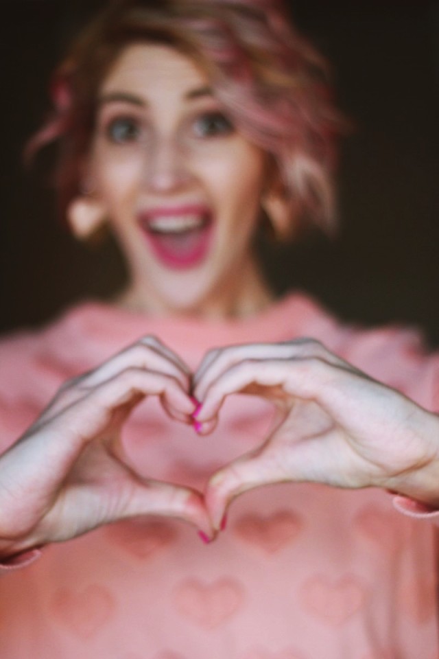 Valentine's Day to Night Outfit | theoutfitrepeater.com A heart formation and a pink sweatshirt printed with hearts all over it.