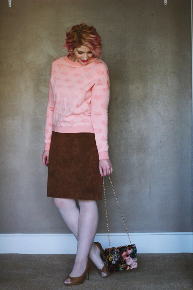 A heart printed pink sweatshirt is worn for a day to night outfit on Valentine's Day.