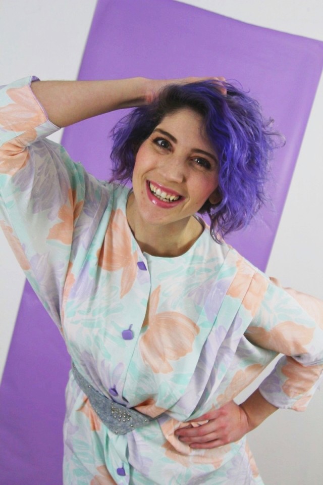 1980's fashion outfit: pastel tunic, gray leggings, violet curly hair, acid washed belt