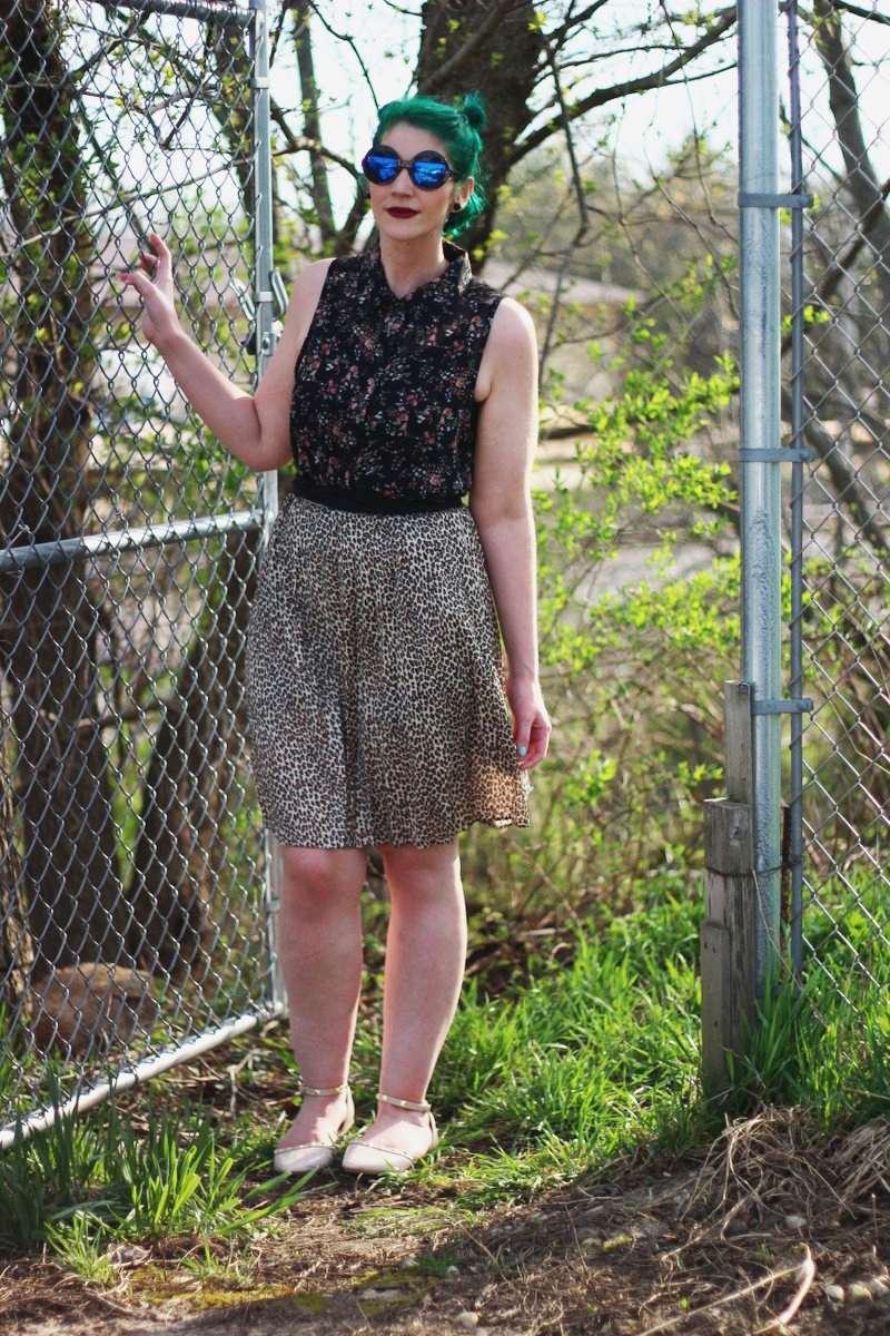 Anti-spring outfit: floral sleeveless button up, leopard print skirt, round sunglasses, green hair, studded nude flats