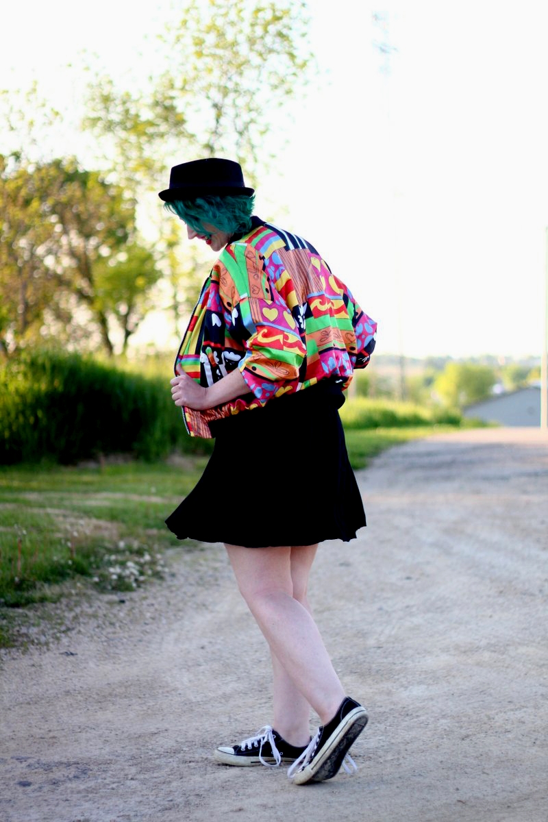 A Colorful Bomber Jacket + Tips For Wearing Statement Clothes | theoutfitrepeater.com Outfit: brightly patterned jacket, striped top, black skirt, thick white belt, green hair, pork pie hat, red lipstick, black sneakers