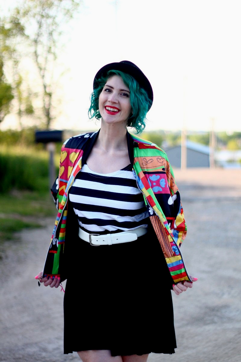 Outfit: brightly patterned jacket, striped top, black skirt, thick white belt, green hair, pork pie hat, red lipstick