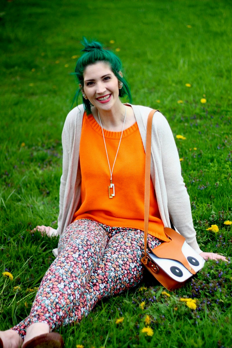 Outfit: vintage orange tank top, beige cardigan, green mini bun hairstyle, thrifted floral pants, brown high heels, gold necklace