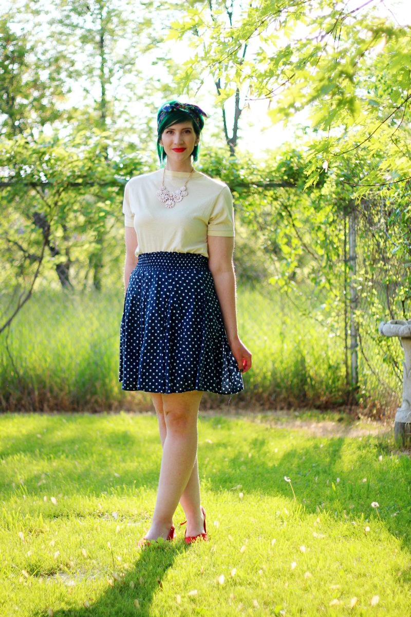 Outfit: primary colors, yellow t-shirt, navy blue polka dot skirt, floral headscarf, flower bib necklace, red lipstick, red kitten heels