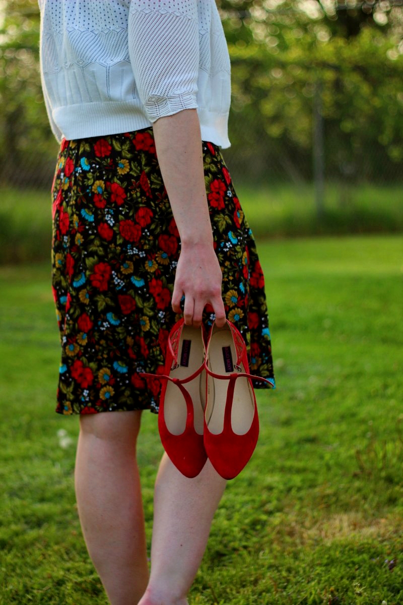 Outfit details: black floral skirt, white cardigan, red t-strap flat shoes
