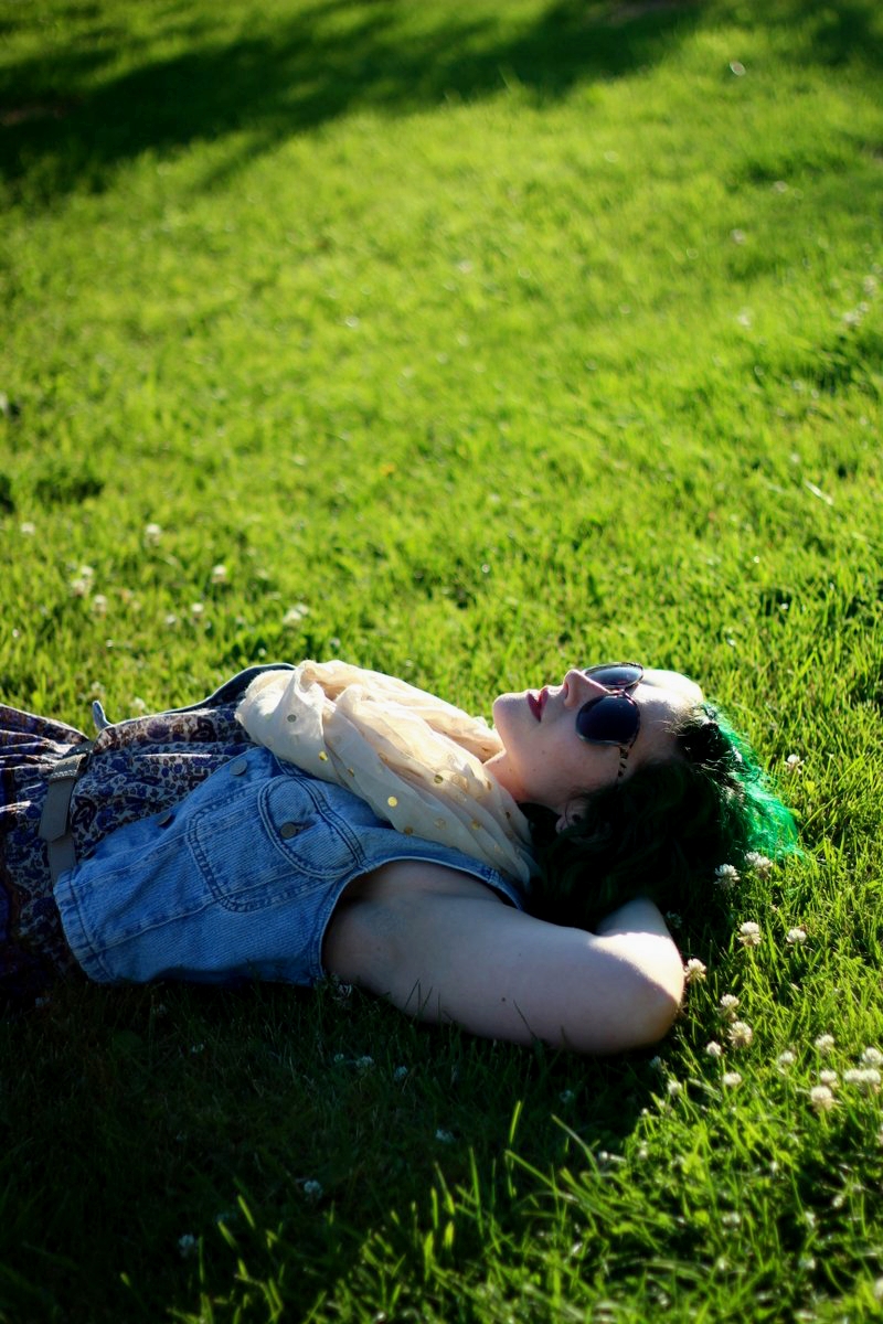 Outfit: patterned summer dress, light wash denim vest, gold polka dot scarf, beige belt, sunglasses, green hair