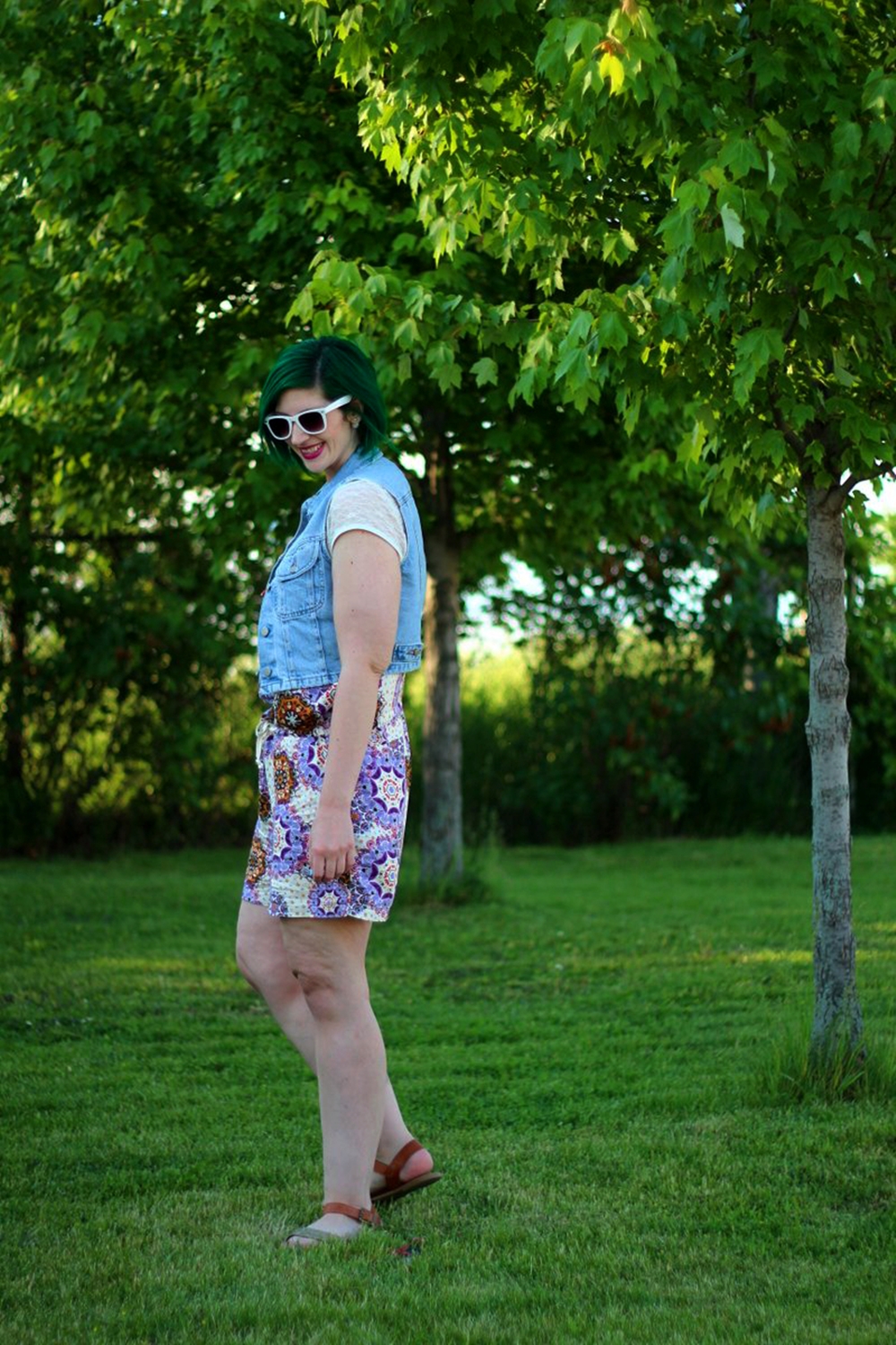 Outfit: purple boho romper overalls, white lace tee, light wash denim vest, green hair, purple lipstick, white sunglasses, Target glitter sandals