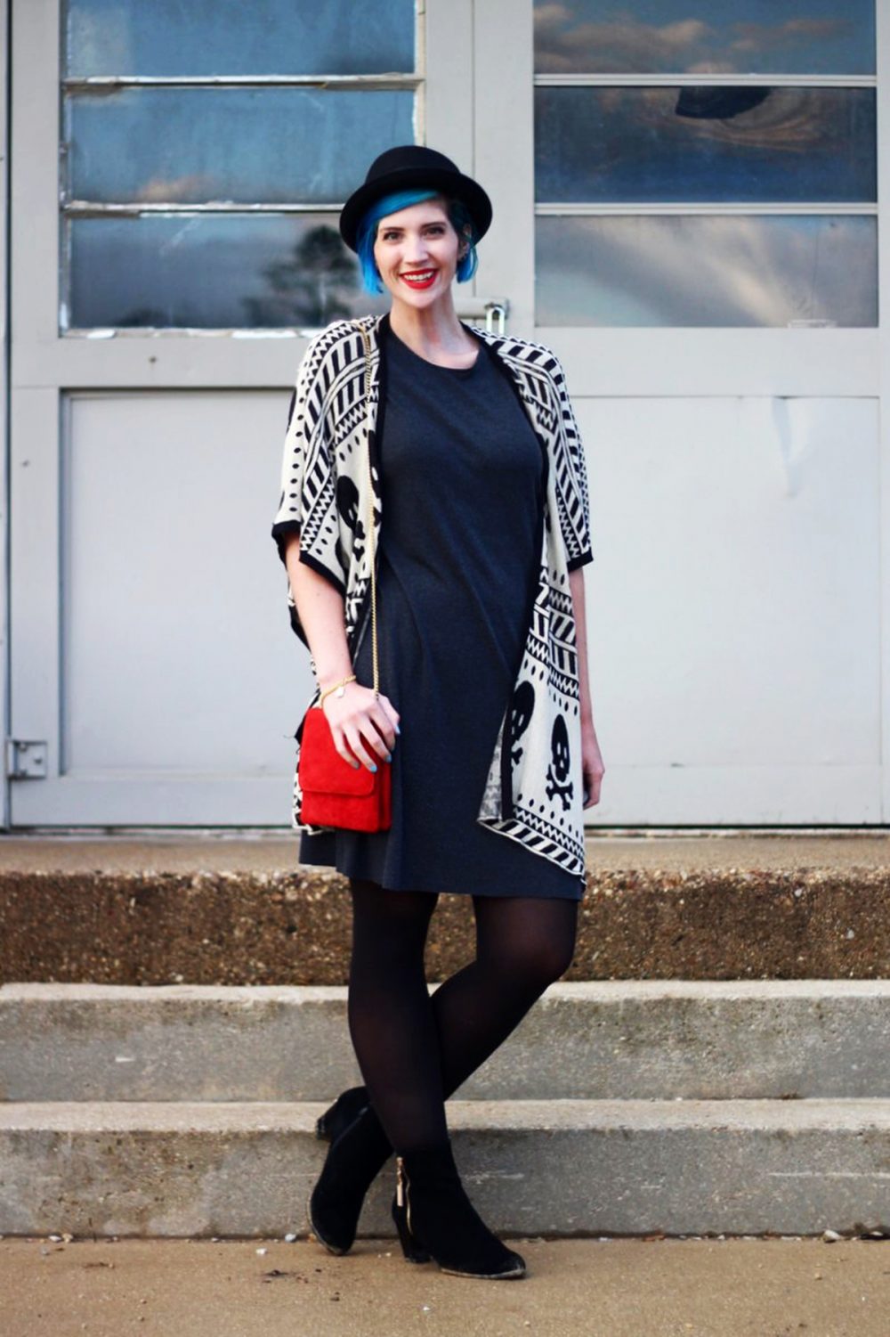 Outfit: Wearing a cardigan with a skull pattern, thrifted gray t-shirt dress, red purse, red lipstick, blue hair, black pork pie hat, black tights, black booties