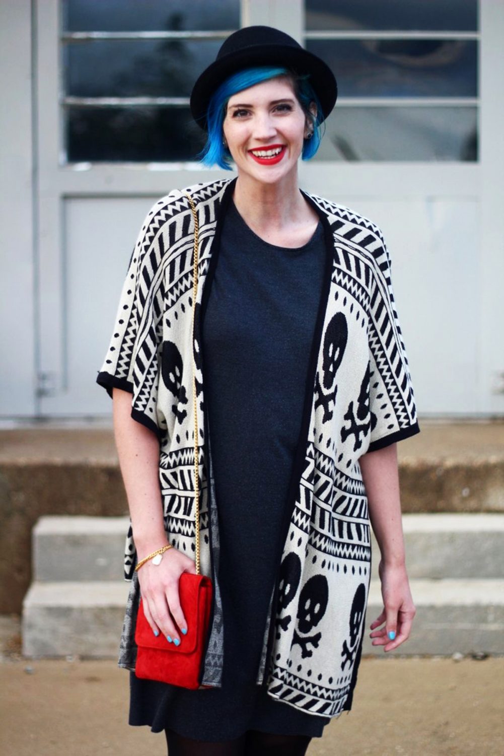 Outfit: Wearing a cardigan with a skull pattern, thrifted gray t-shirt dress, red purse, red lipstick, blue hair, black pork pie hat,