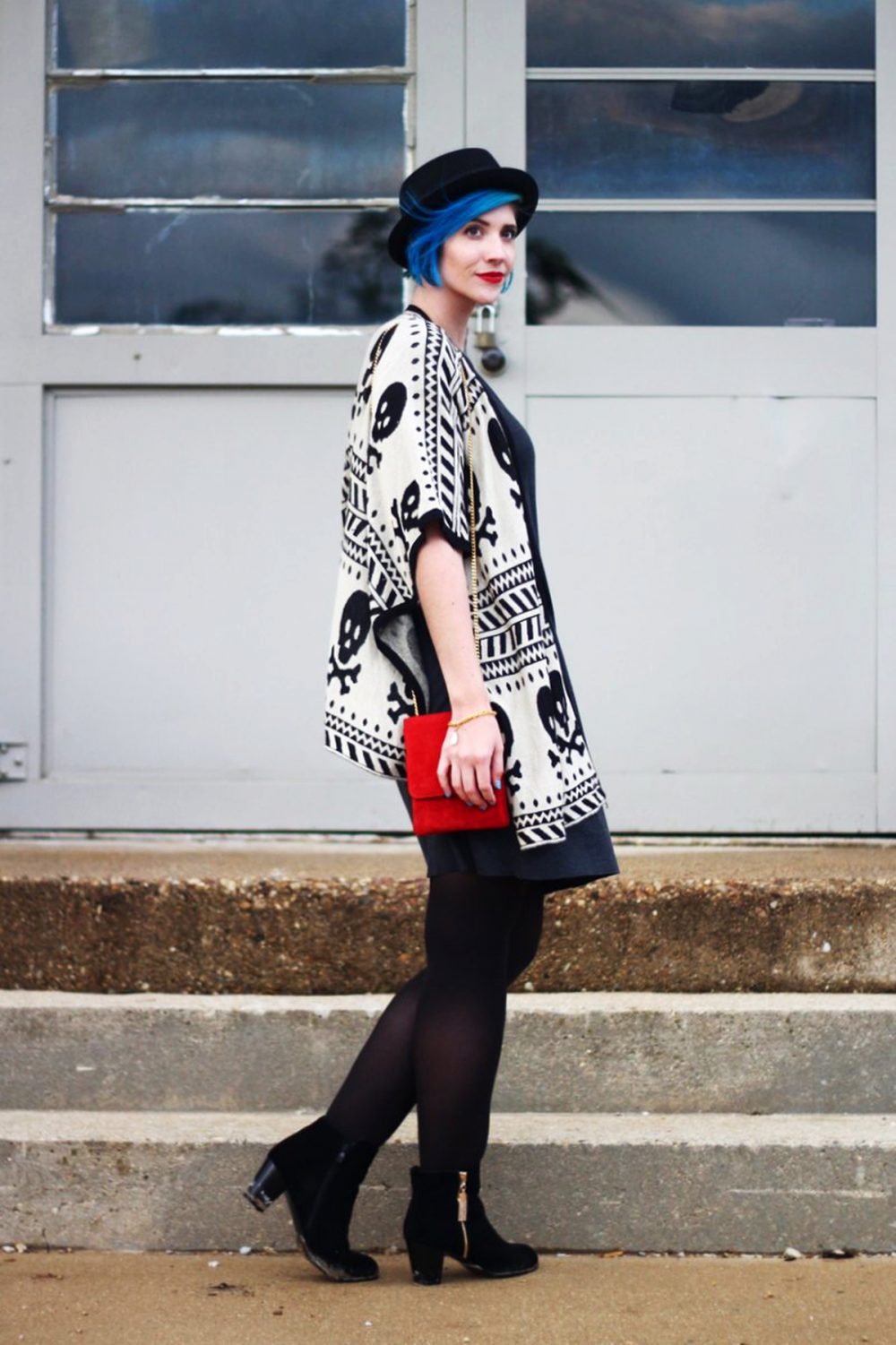 Outfit: Wearing a cardigan with a skull pattern, thrifted gray t-shirt dress, red purse, red lipstick, blue hair, black pork pie hat, black tights, black booties