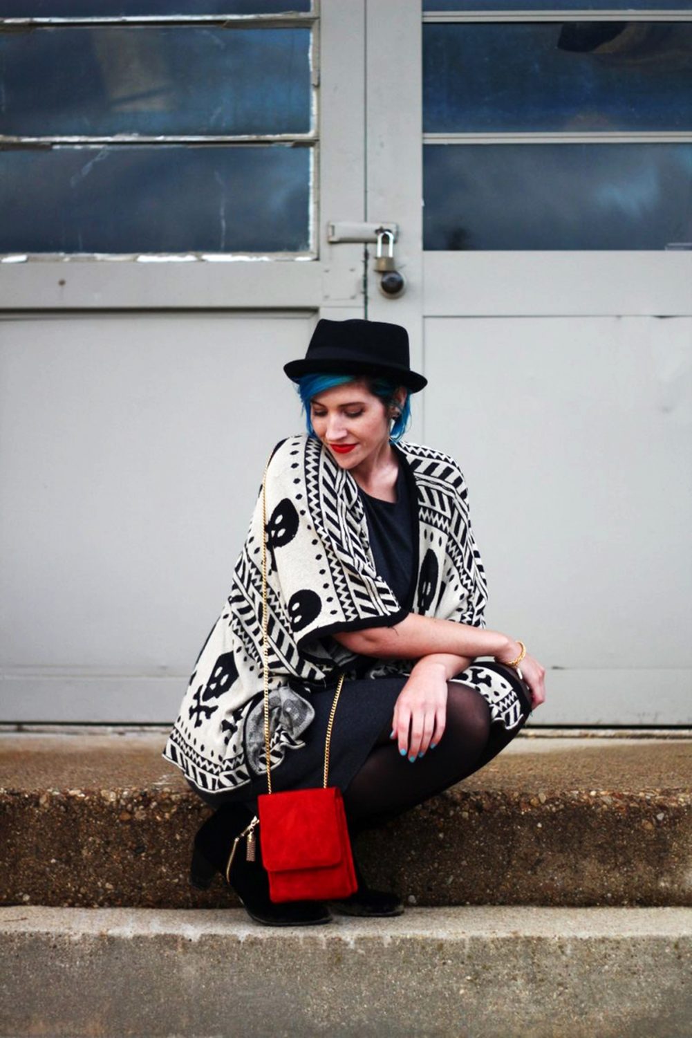 Outfit: Wearing a cardigan with a skull pattern, thrifted gray t-shirt dress, red purse, red lipstick, blue hair, black pork pie hat, black tights, black booties