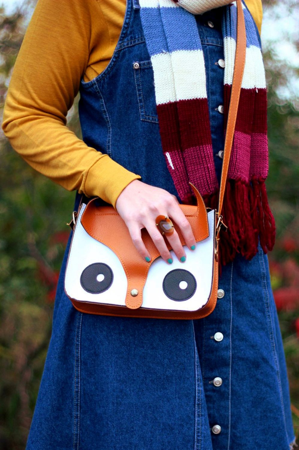 Outfit details: Mustard yellow turtleneck, denim overall dress, multi-colored striped scarf, orange fox handbag
