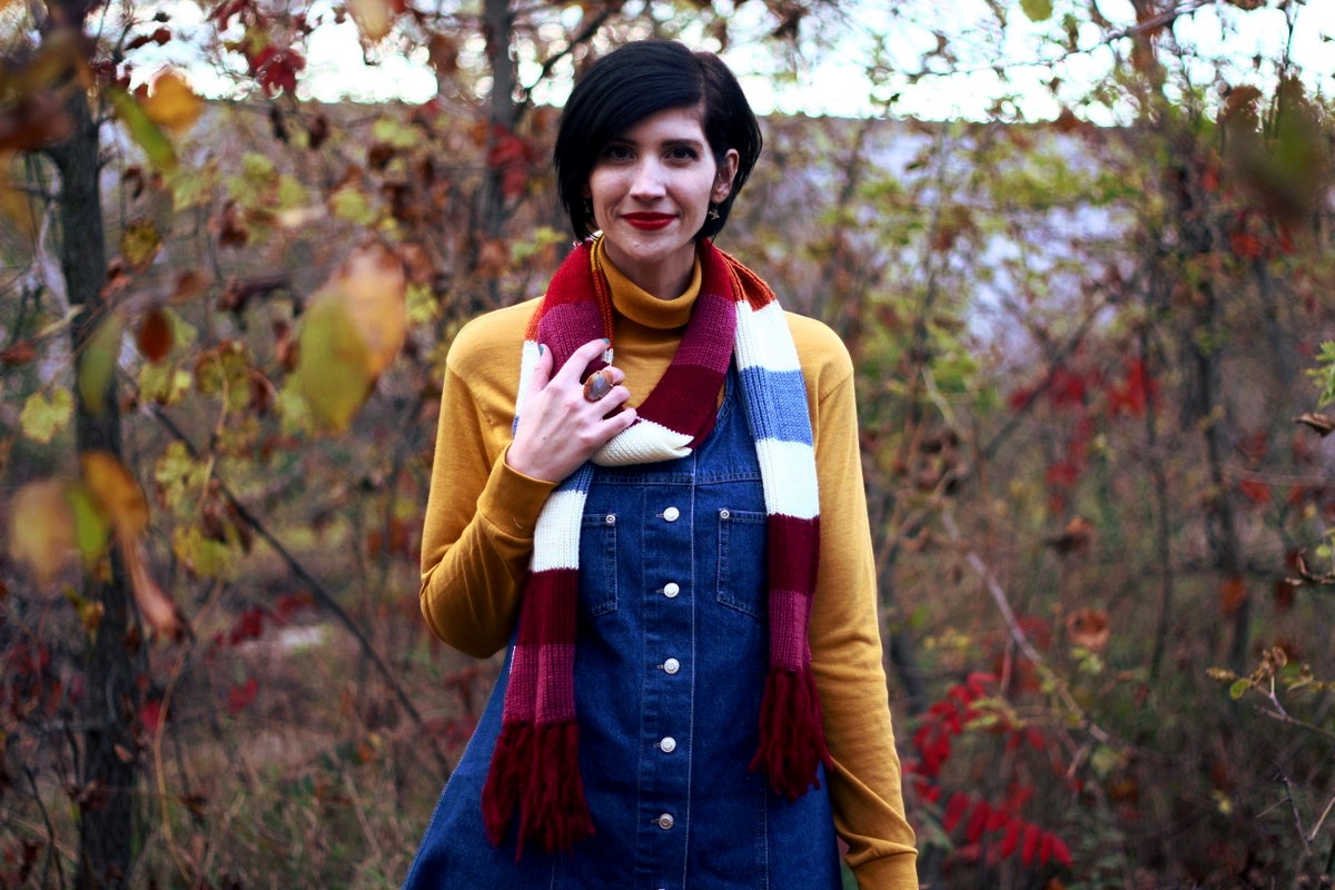 Outfit: Mustard yellow turtleneck, denim overall dress, multi-colored striped scarf, red lipstick