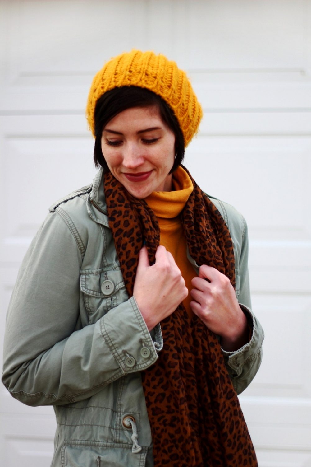 Outfit: mustard yellow turtleneck, olive green utility jacket, leopard print scarf, yellow knit hat, black skater skirt