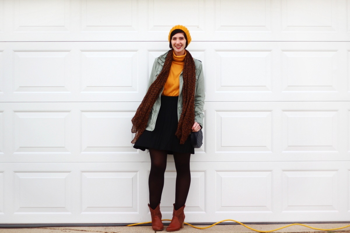 Outfit: mustard yellow turtleneck, olive green utility jacket, leopard print scarf, yellow knit hat, black skater skirt, black tights, cognac colored boots, navy blue quilted purse