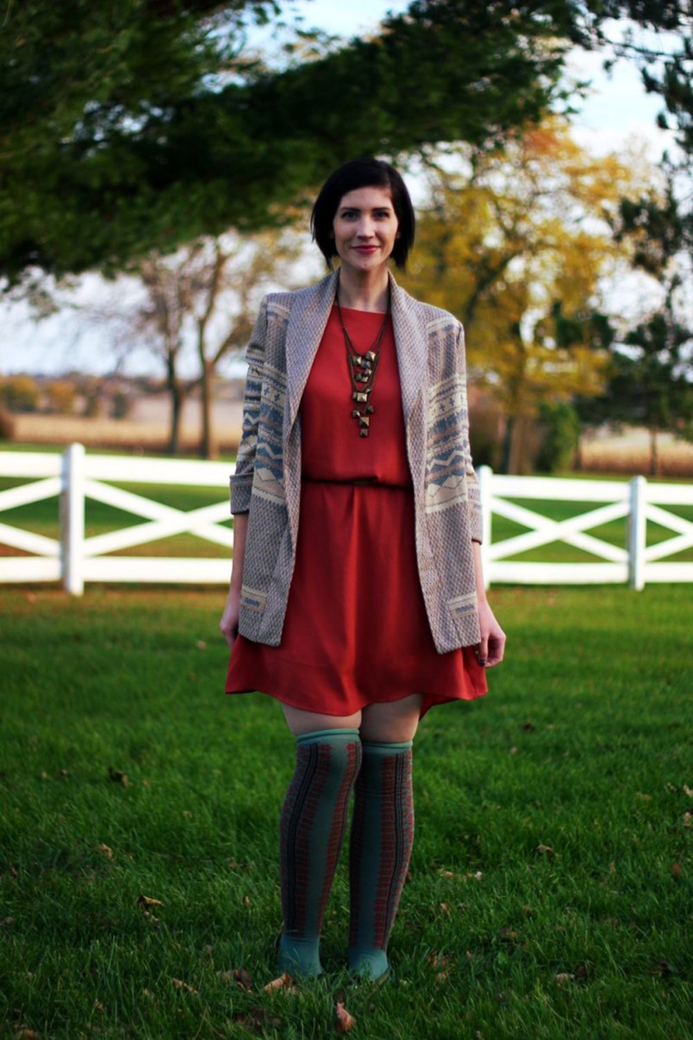 Outfit: Orange dress, beige belt, bronze necklace, patterned cardigan, otk colorful socks, brown flats 