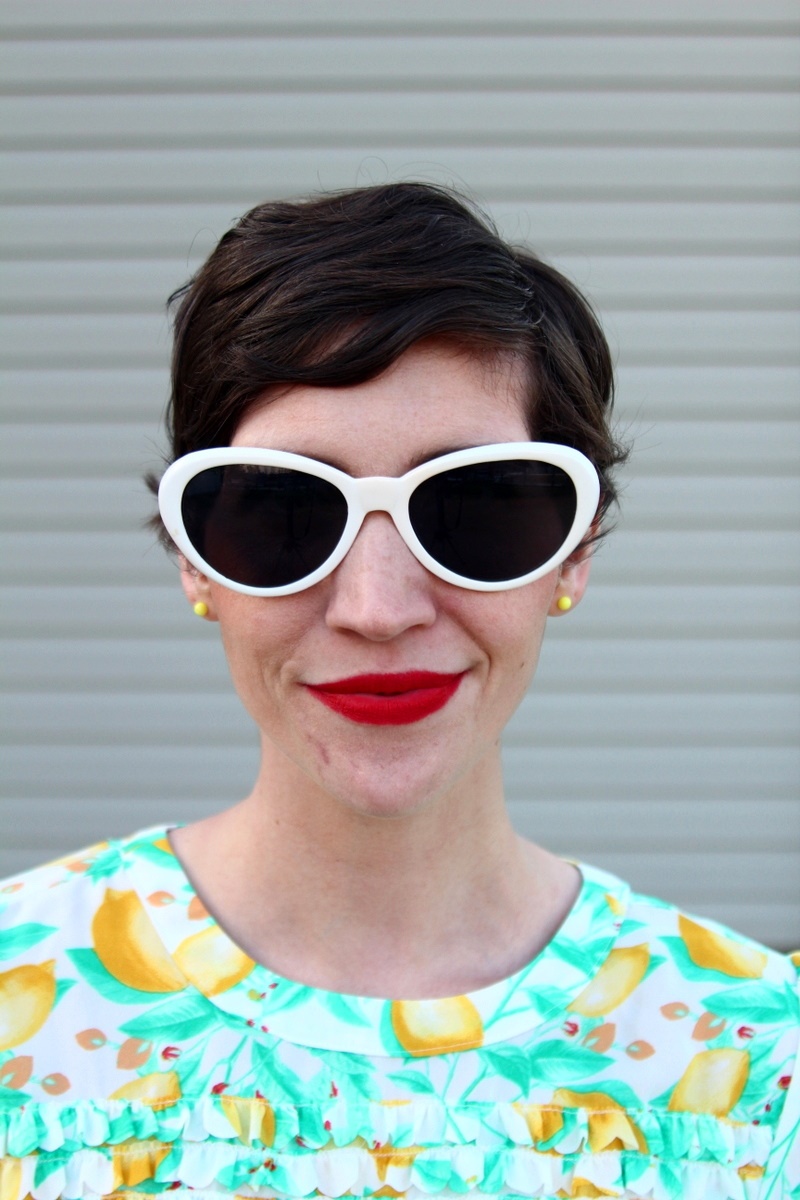 outfit Lemon print blouse, high waisted jeans, red flats, MAC Ruby Woo lipstick, curly pixie haircut, red purse