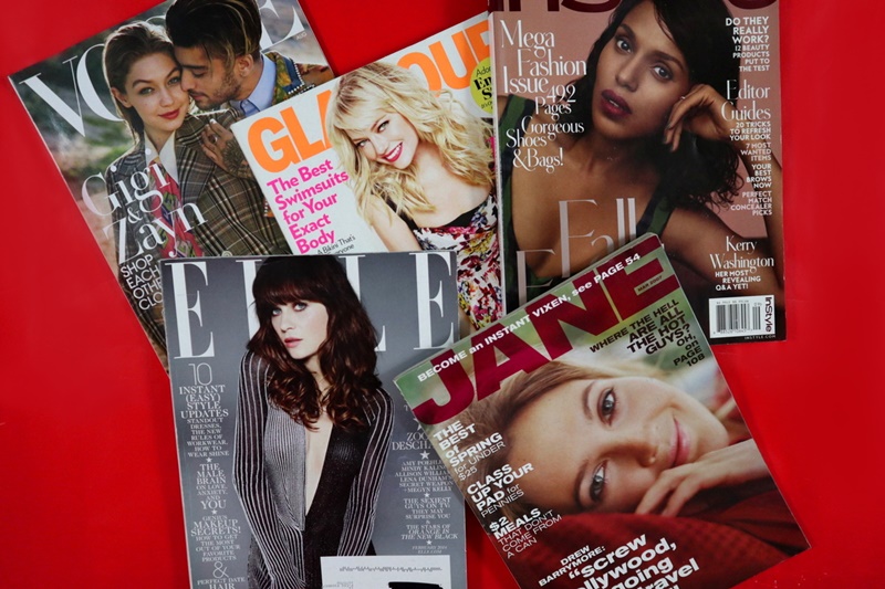 red background, pile of fashion magazines with celebrity faces, hannah rupp the outfit repeater