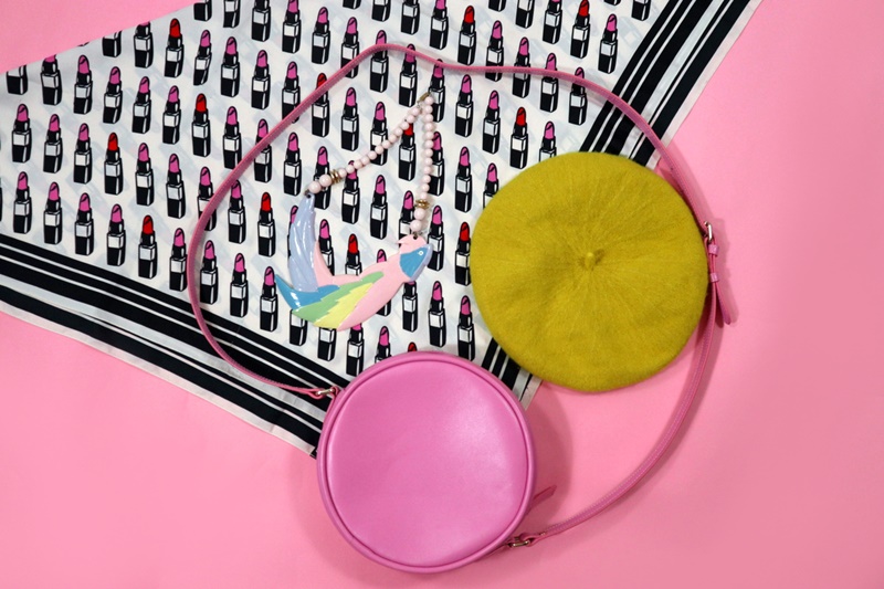 My Top 6 Style Goals of 2022 | www.theoutfitrepeater.com accessories against a pink background. lipstick print scarf, yellow beret, round pink purse, pastel parrot necklace. "hannah rupp" "the outfit repeater"