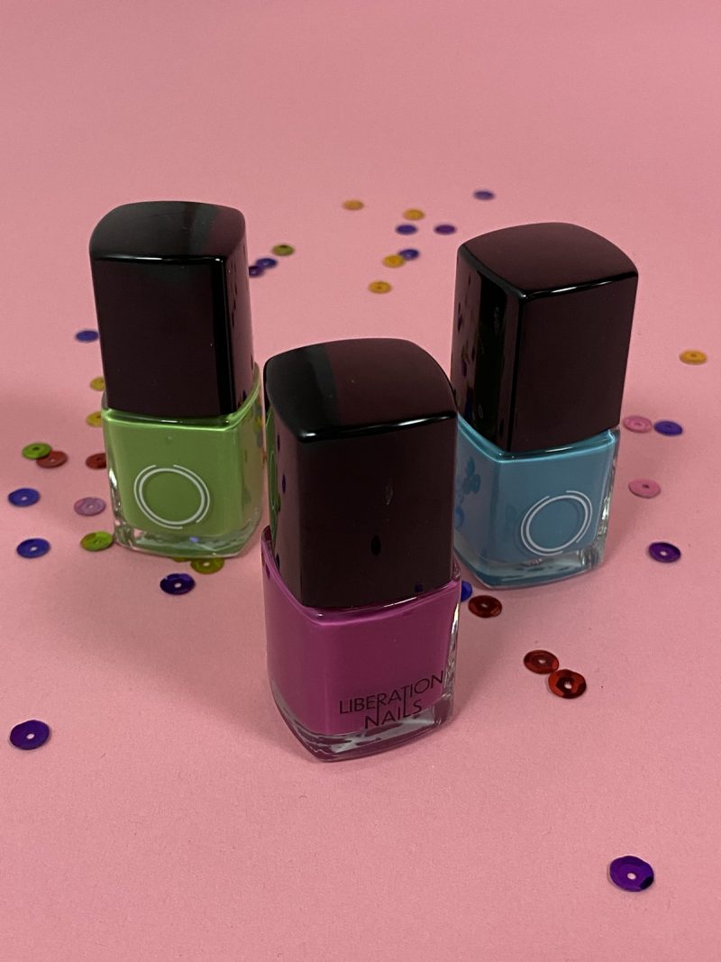 bottles of liberation nail colors green purple and teal
