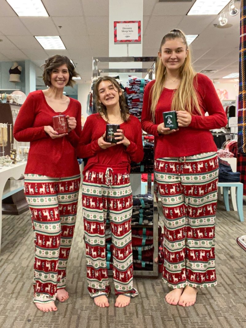 hannah is wearing maurices clothing - she and her 2 coworkers are standing the store wearing red holiday pajama sets