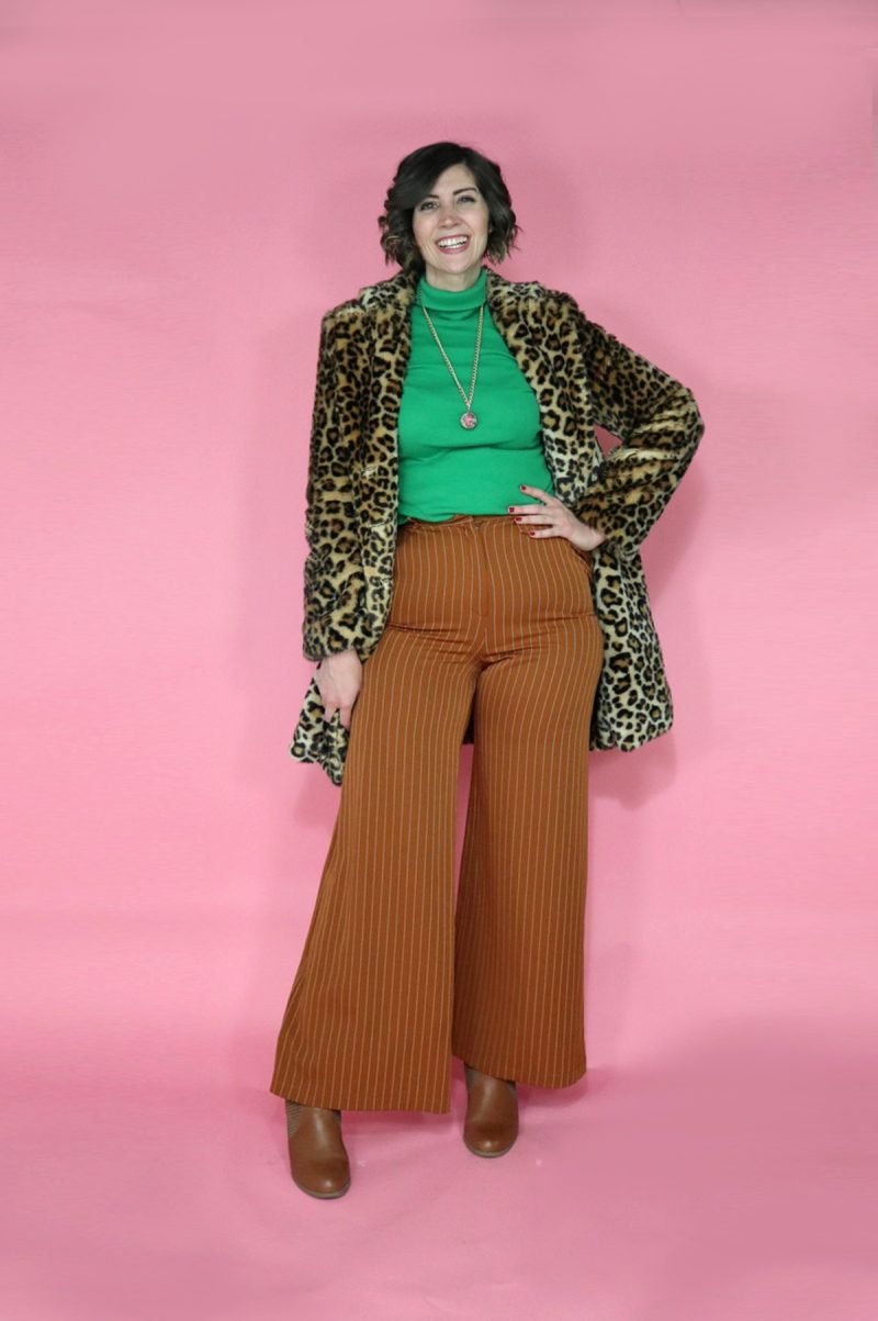 TikTok Outfit Challenge: My Followers Pick My Outfit For 1 Week | theoutfitrepeater.com hannah is wearing a green turtleneck with burnt orange palazzo pants. on top is an oversized furry leopard print coat.