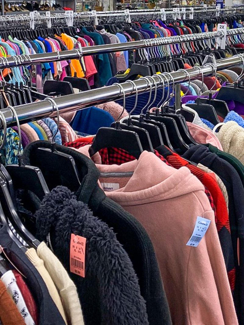 colorful clothes hanging up in a thrift store
