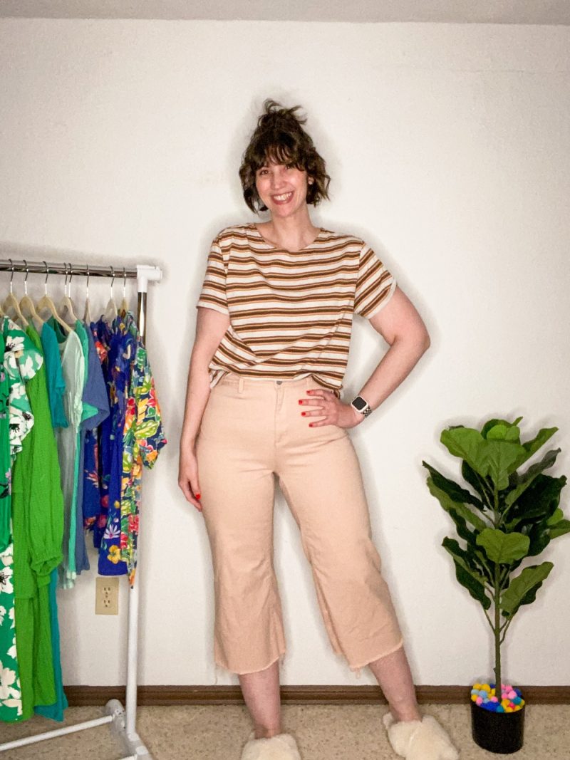 hannah is smiling wear a brown striped crop top and peach wide leg capri pants from thredup