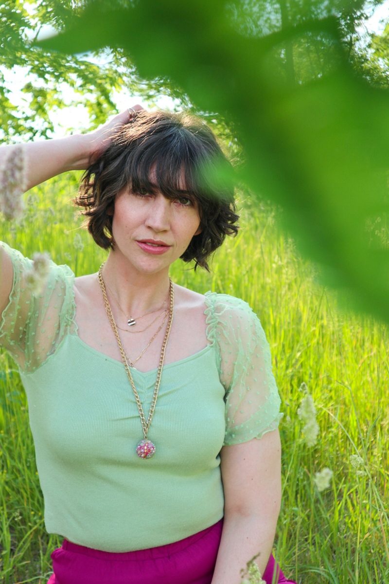 This Outfit Will Convince You To Wear Those Fancy Clothes You've Been Saving | www.theoutfitrepeater.com hannah rupp is in a bright, green field. she's wearing a mint green blouse and gold jewelry.