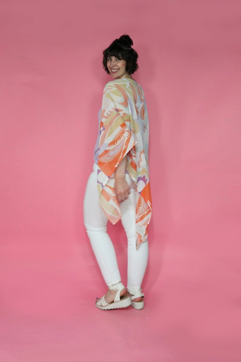A thredUP Summer Thrift Haul | What I'm Keeping + Returning | www.theoutfitrepeater.com hannah is wearing a long colorful kimono, white jeans, and white platform sandals. she's smiling in front of a pink background.