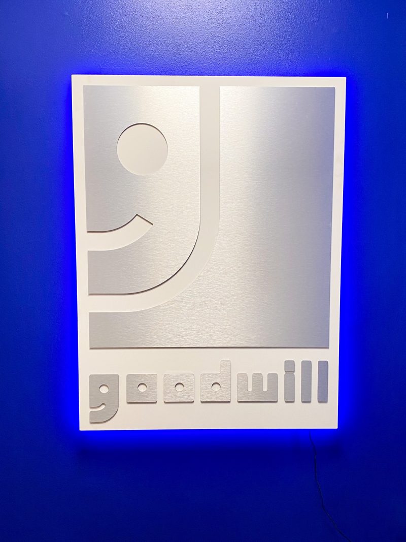 illuminated goodwill logo and bright blue wall