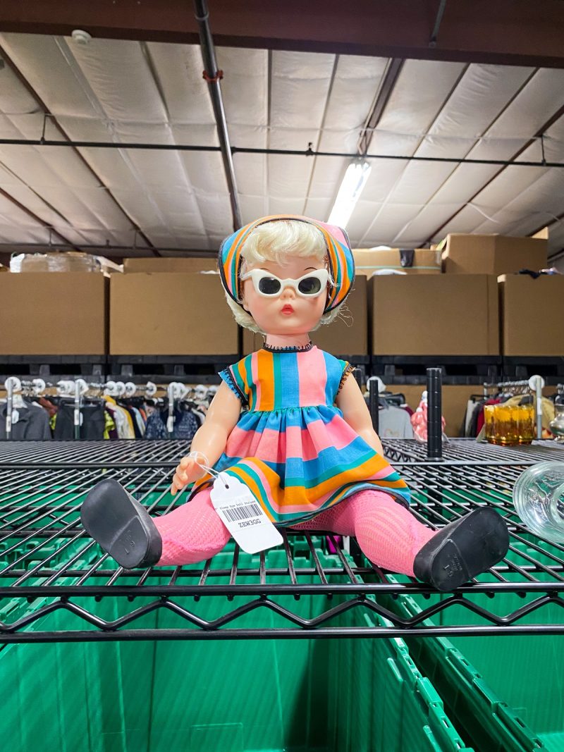 a vintage baby doll in brightly dress clothing for sale