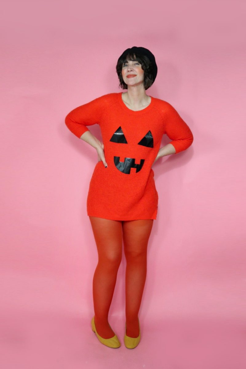 an orange sweater, thrifted beret, and tights are transformed into a DIY jack-o'-lantern halloween costume