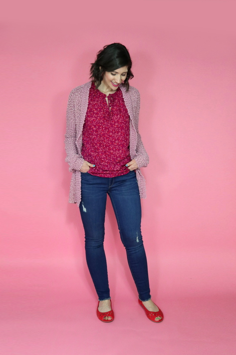 10 Essential Outfits You Should Always Have In Your Closet | theoutfitrepeater.com White female with short brown hair looking down while wearing a red blouse mauve cardigan and a pair of skinny jeans