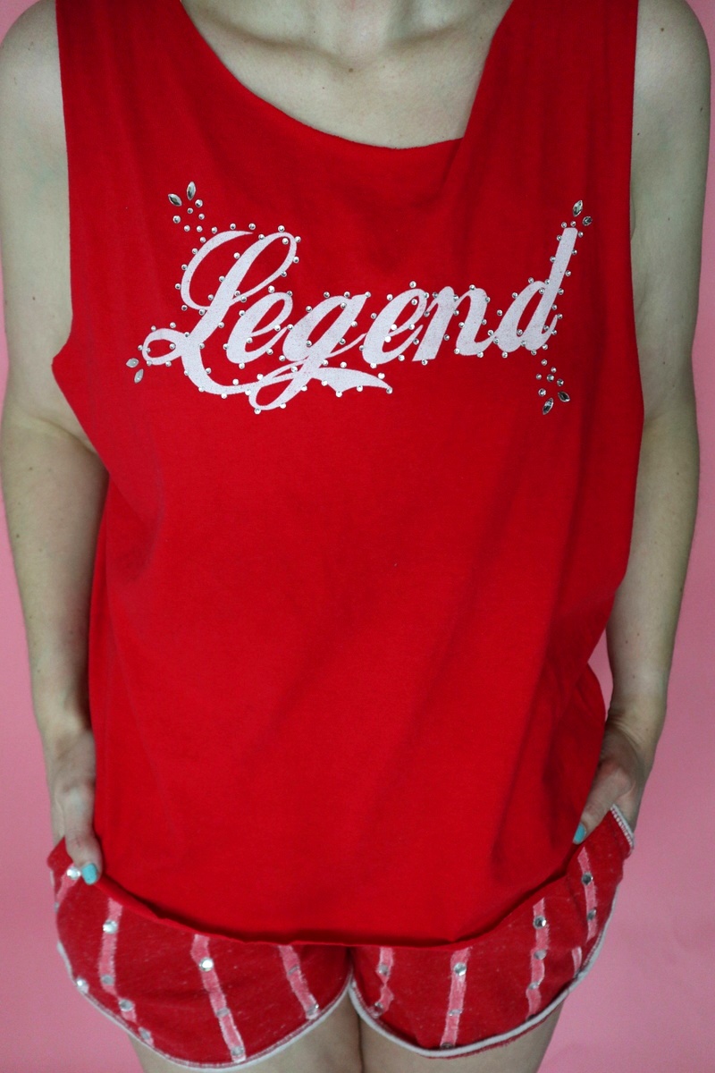 An Iconic Richard Simmons Halloween Costume | www.theoutfitrepeater.com thrifted richard simmons halloween costume red tank top, tiny striped dolphin shorts, curly hair, and white sneakers