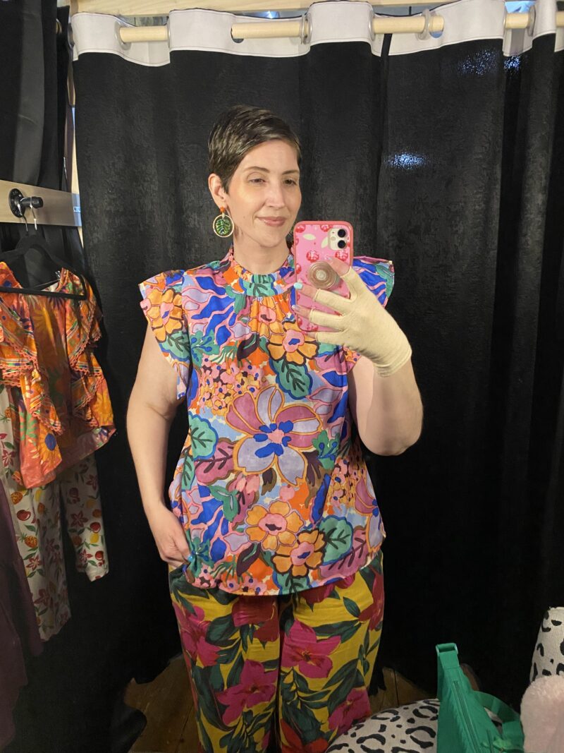 What I Thrifted vs. How I Styled It | www.theoutfitrepeater.com a white female with short brown hair takes a mirror selfie wearing a colorful blouse and printed pants